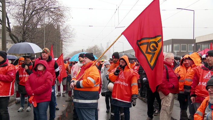 Stahlarbeiter in orangenen Warnwesten vor dem Thyssenkrupp Stahlwerk