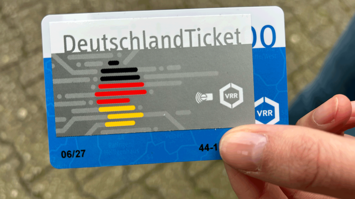 Eine Person hält das Deutschlandticket in der Hand