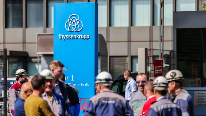 Mitarbeitende stehen vor dem Thyssenkrupp-Gebäude