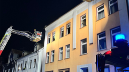 zu sehen ist ein Mehrfamilienhaus und Feuerwehrleute