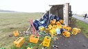 Zu sehen ist ein auf die Seite gekippter Getränkelastwagen. Es sind viele leere Getränkekisten verstreut und einzelne Flaschen liegen auf dem Boden und zum Teil auf der Straße.