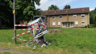 Ein gesprengter Zigarettenautomat vor einem Wohnhaus, umwickelt mit Polizeiabsperrungen