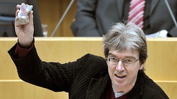 Der parteilose Abgeordnete Rüdiger Sagel hält am 12.03.2008 in Düsseldorf im nordrhein-westfälischen Landtag ein Stück der Berliner Mauer hoch. 