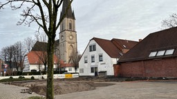 Große Baugrube neben einer Kirche.