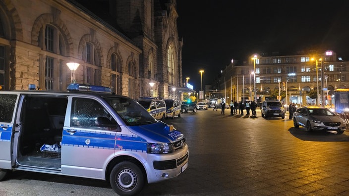 Ein Polizeiwägen und Polizisten stehen nach den Polizeischüssen an einem Krefelder Kino vor dem Bahnhof