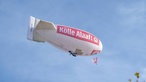 Heißluftballon mit Aufschrift "Kölle Alaaf!" fliegt über dem Heumarkt