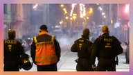 Polizisten und ein Rettungssanitäter stehen an einer Kreuzung