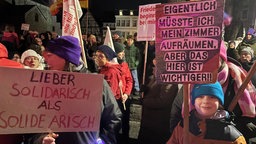 Junge mit Schild mit der Aufschrift "Eigentlich müsste ich mein Zimmer aufräumen, aber das hier ist wichtiger".