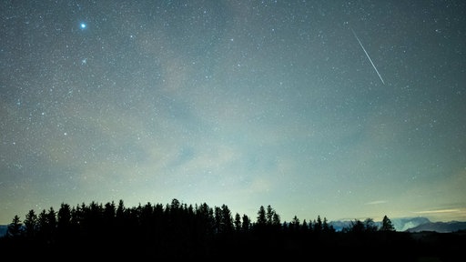 Eine Sternschnuppe ist während des Geminiden-Meteteorstroms am Sternenhimmel über dem Alpenpanorama mit der Zugspitze (r) zu sehen