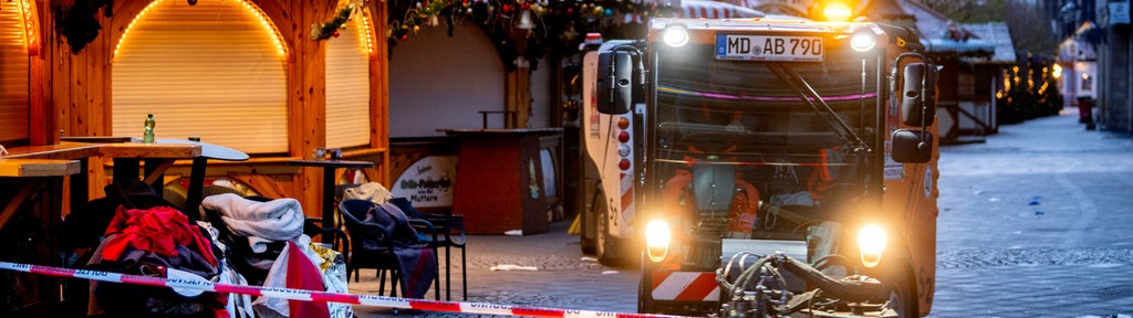 Straßenkehrmaschine fährt über den Magdeburger Weihnachtsmarkt