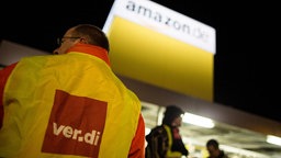 Ein Verdmitglied mit Verdi-Streikweste vor dem Amazongebäude in Koblenz