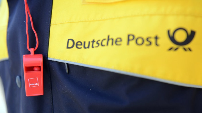 Ein Mitarbeiter der Deutschen Post demonstriert im Rahmen eines Warnstreiks der Gewerkschaft Verdi