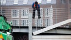 Ein Mitarbeiter der Stadt Düsseldorf schließt das Tor am Unteren Rheinwerft zum Alten Hafen