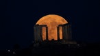 Der Supermond geht hinter dem Poseidon-Tempel am Kap Sounio südlich von Athen auf