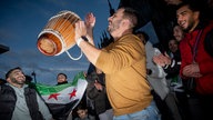 Syrer feiern das Ende des Assad Reginmes vor dem Koelner Hauptbahnhof