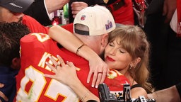 Travis Kelce und Taylor Swift umarmen sich 