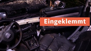 Zerstörter und verformter Autoinnenraum; Text: Eingeklemmt