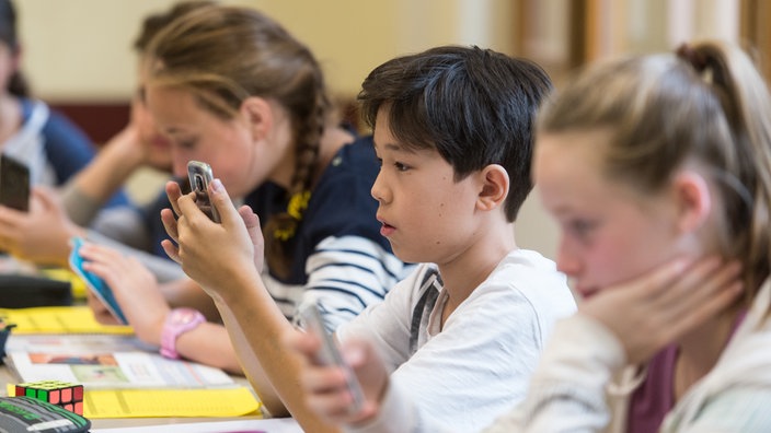 Schüler arbeiten im Unterricht mit dem Smartphone