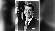 Offizielles Porträt von US-Präsident Reagan: Schwarz-weiß-Foto eines freundlich in die Kamera lächelnden Mannes