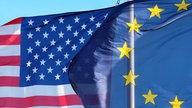 Die Flaggen der USA (links) und der EU wehen im Wind