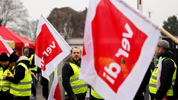 Streikende halten Verdi-Flaggen hoch