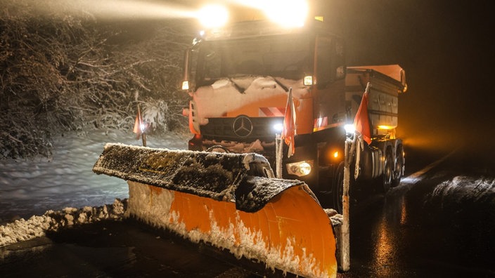 Ein orangenes Räumungsfahrzeug, befreit die A45 vom Schnee