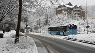 Ein Bus fährt über ein verschneite Straße