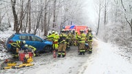 Unfall zwischen zwei Pkw auf winterlicher Hauptverbindungsstraße im schneenedeckten Wald in Herdecke