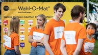 Wahl-O-Mat Plakat mit jungen Leuten davor