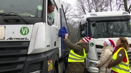 Drei Frauen bei der Übergabe des Geschenks an Lkw-Fahrer