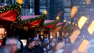 Weihnachtsmarkt am Kölner Dom; Im Hintergrund die Buden im Fordergrund (unscharf) Menschen