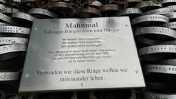 Metallplatte, die Beschriftung für das Mahnmal trägt