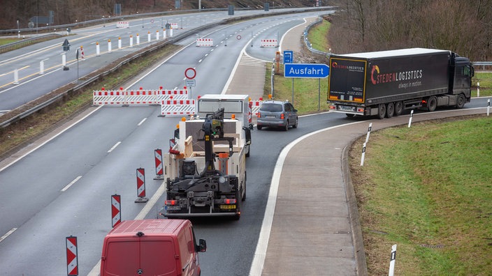 Autos und Lastwagen fahren kurz vor einer Sperrung von der Autobahn ab.