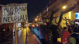 Menschen und Traktoren währned der Proteste