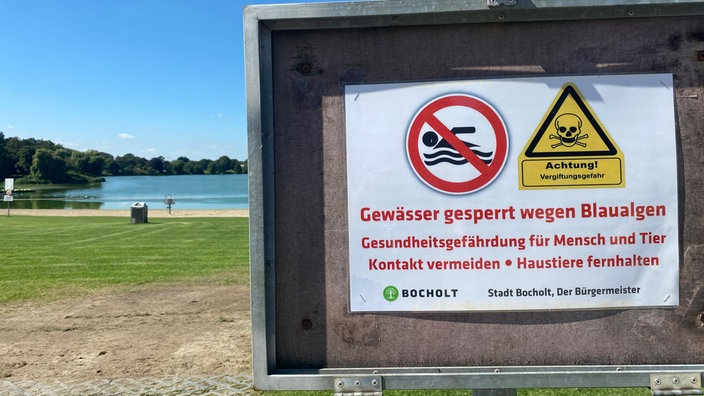 Ein Schild macht auf die Sperrung des Bocholter Aasees aufgrund von Blaualgen aufmerksam.