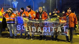 Demonstraten halten ein Banner mit der Aufschrift: Solidarität. Wir mit euch.