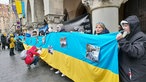 Menschen mit der Flagge der Ukraine vor dem Rathaus in Münster.