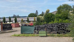 Mehrere Reifenstapel auf einem Industriegelände.