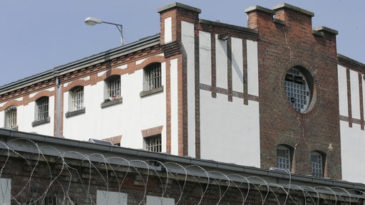 Außenansicht der JVA in Werl mit Stacheldraht auf Mauer