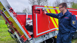 Ein Feuerwehrmann testet ein Fahrzeug mit einem großen Wassersack