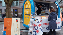 Eine Frau steht vor einem Stand des Uniklinikums Münster, der über Organspende aufklären soll.