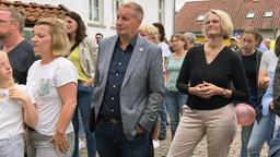 Bürgermeister aus Tecklenburg steht zwischen anderen Menschen, direkt neben ihm steht Anja Karliczek von der CDU