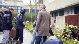 Im Beisein von Schulleiter Christian Krahl legen Schüler weiße Rosen nieder.