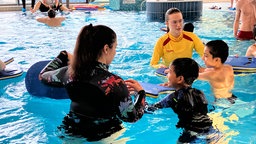 Kinder und Schwimmleherinnen im Schwimmbecken. 