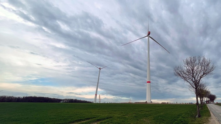 Windkraftanlagen vor bewölktem Himmel.