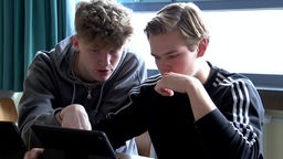 Zwei Schüler schauen gemeinsam auf einen Laptop