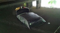 das Auto steht im Wasser unter der Brücke