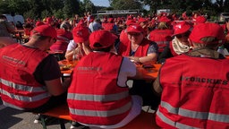 Zahlreiche Menschen sitzen versammelt.