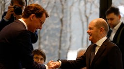 Bundeskanzler Olaf Scholz (r) schüttelt am 6. März 2024 dem nordrhein-westfälischen Ministerpräsidenten Hendrik Wüst (l) die Hand.
