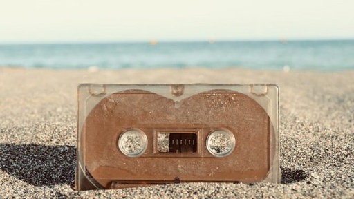 Eine Kassette liegt am Sandstrand